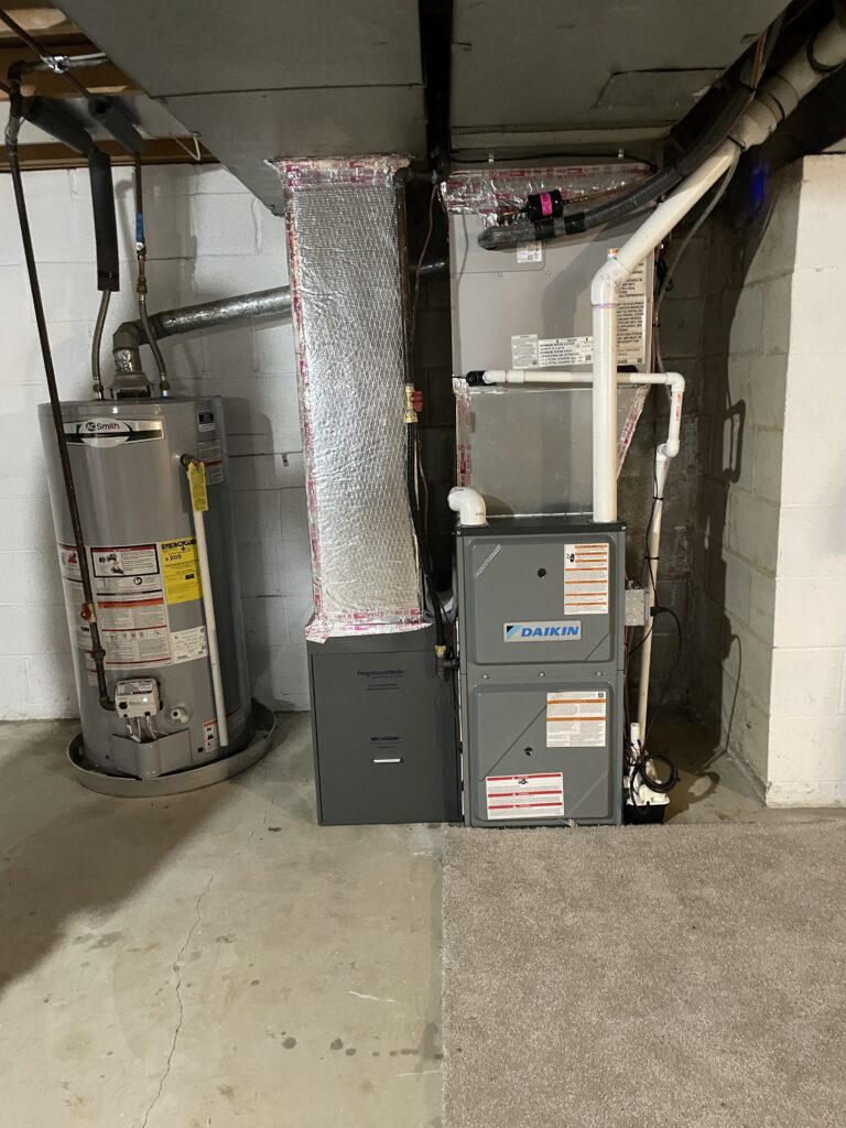 Metro HVAC technician fabricating sheet metal transition during Daikin furnace installation in Camp Hill PA