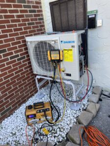 Service gauges and a vacuum pump connected to a Daikin FIT heat pump during installation in Mechanicsburg, PA.