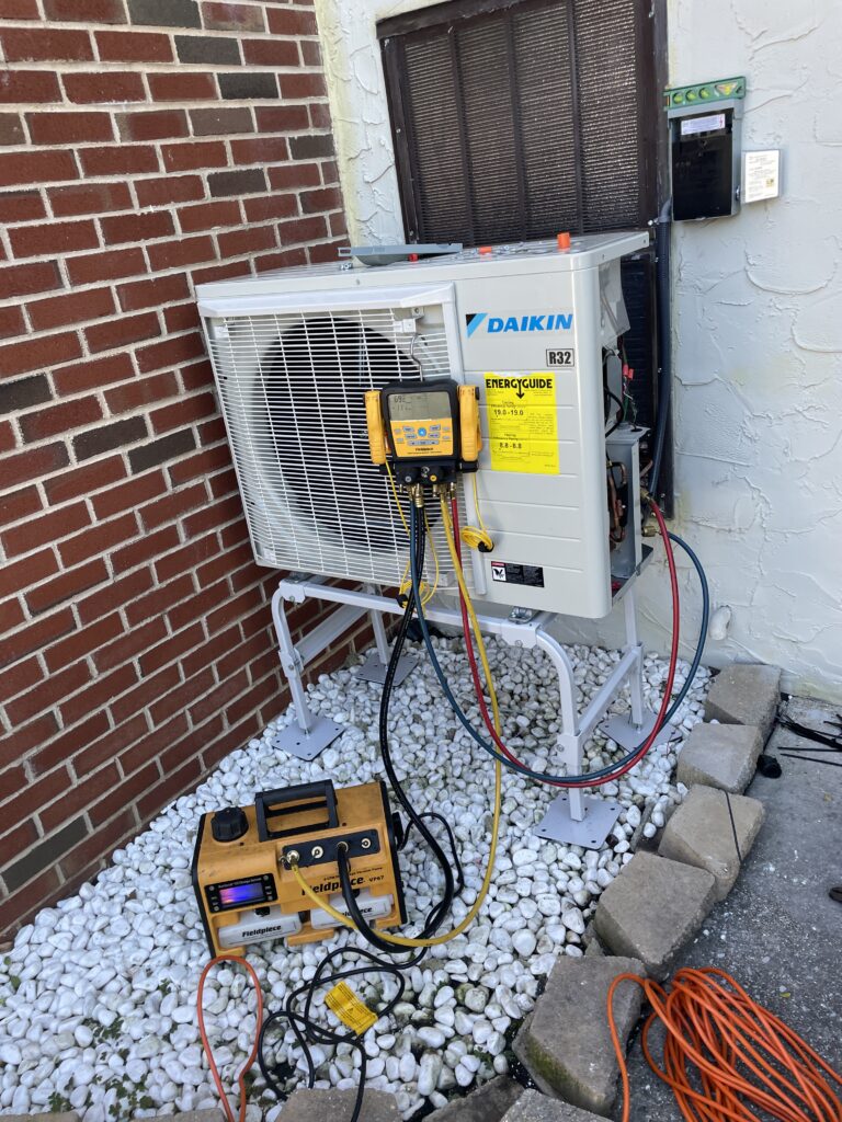 Service gauges and a vacuum pump connected to a Daikin FIT heat pump during installation in Mechanicsburg, PA.