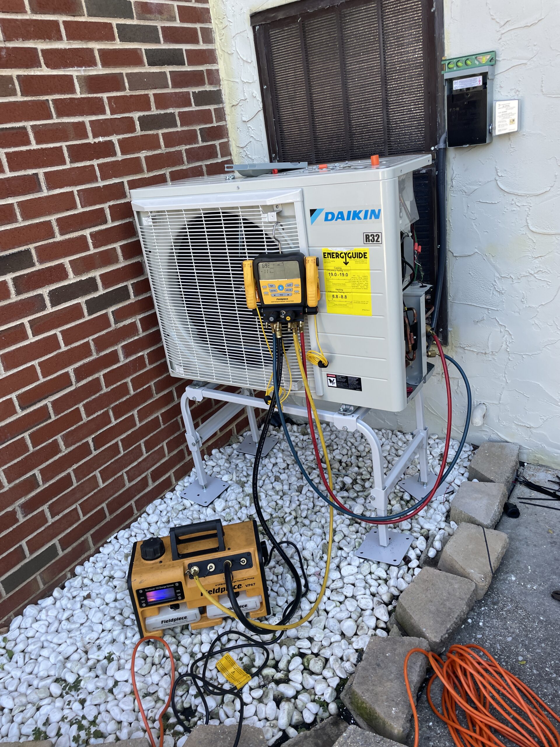 Service gauges and a vacuum pump connected to a Daikin FIT heat pump during installation in Mechanicsburg, PA.