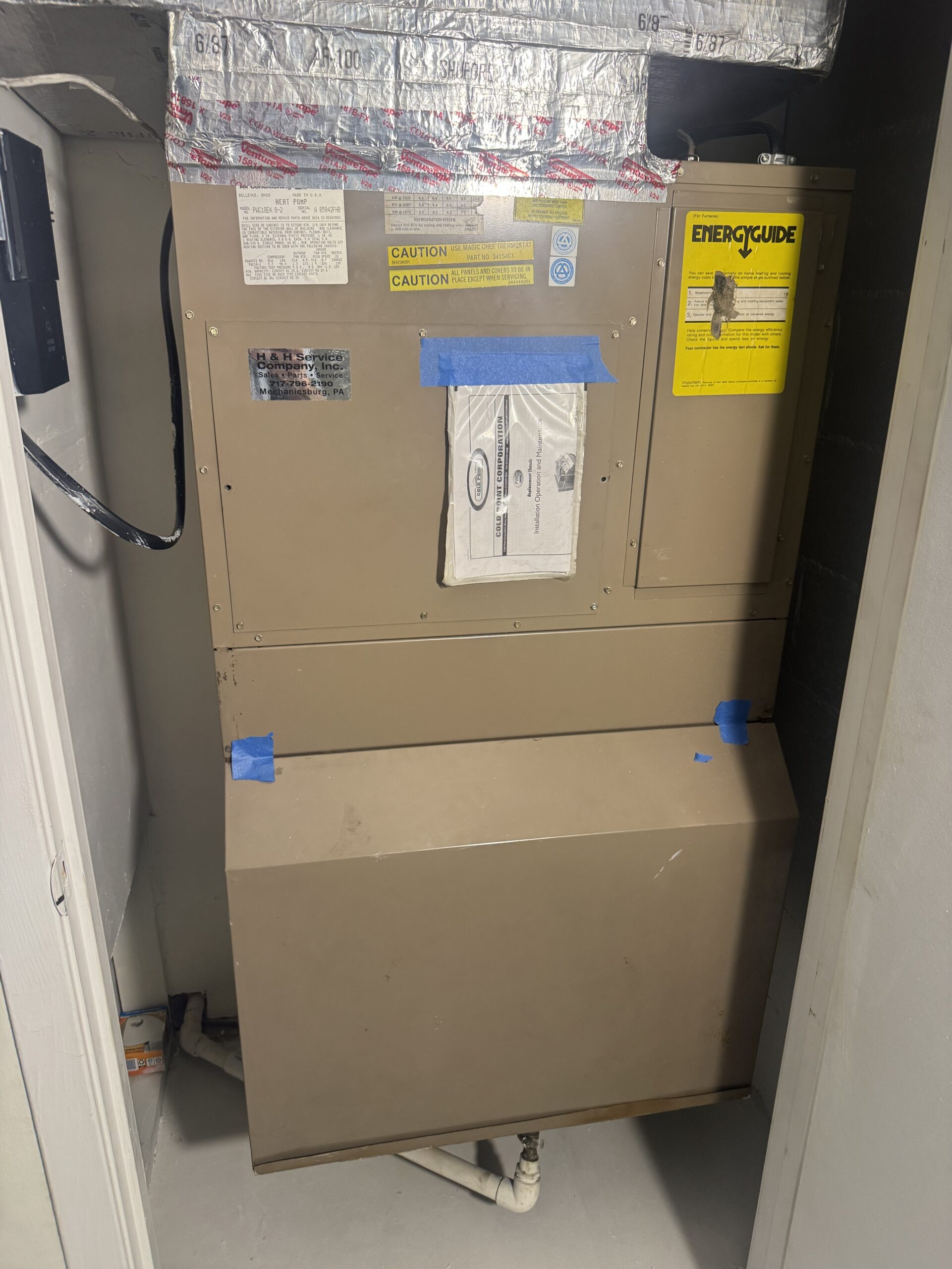 Original through-the-wall heat pump in the utility space before replacement in Mechanicsburg, PA.